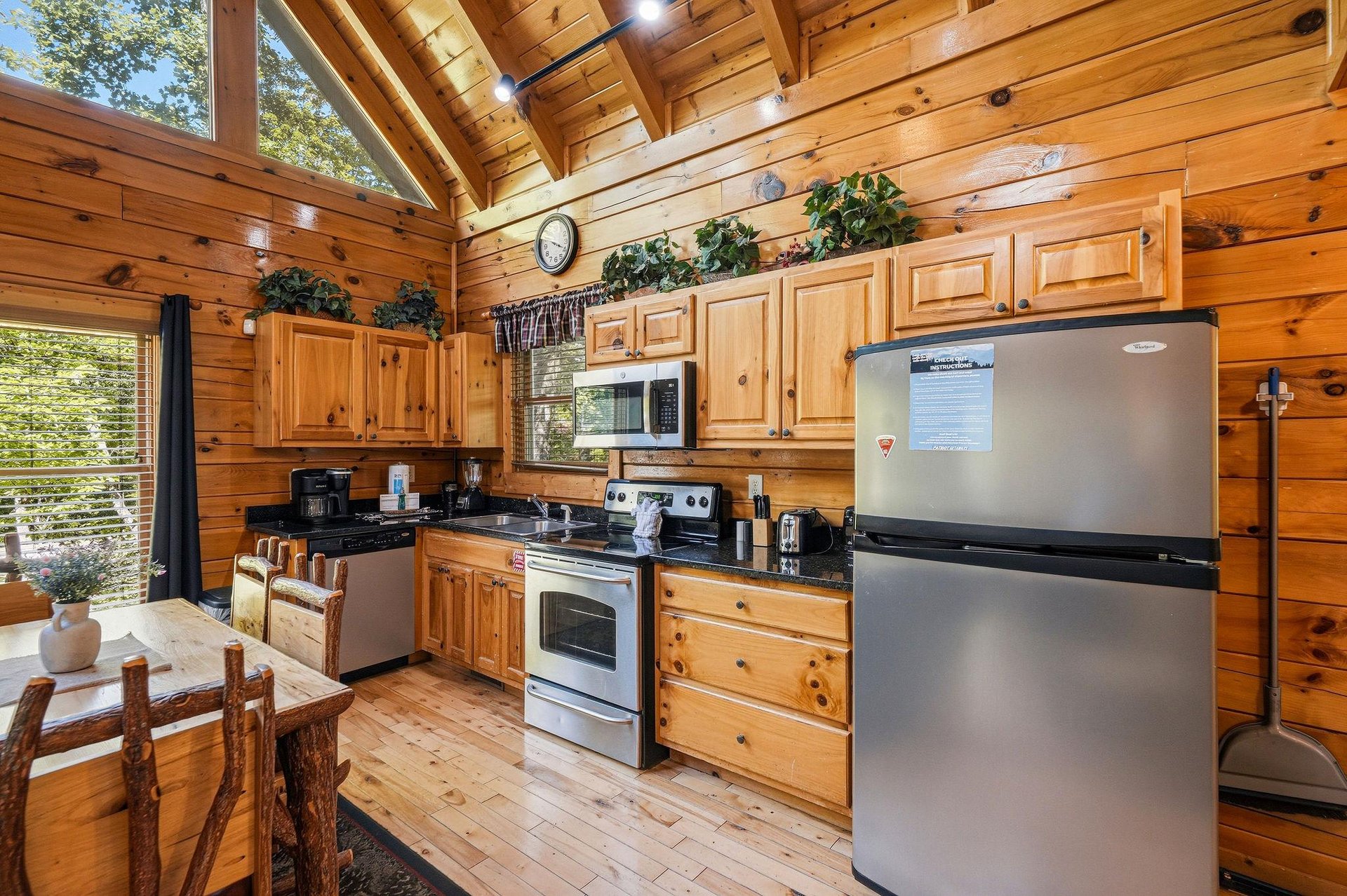 Step into your warm cabin kitchen with soaring wood ceilings, natural light streaming in, and everything you need to cook, gather, and feel right at home.