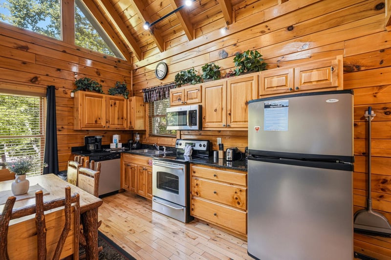 Step into your warm cabin kitchen with soaring wood ceilings, natural light streaming in, and everything you need to cook, gather, and feel right at home.