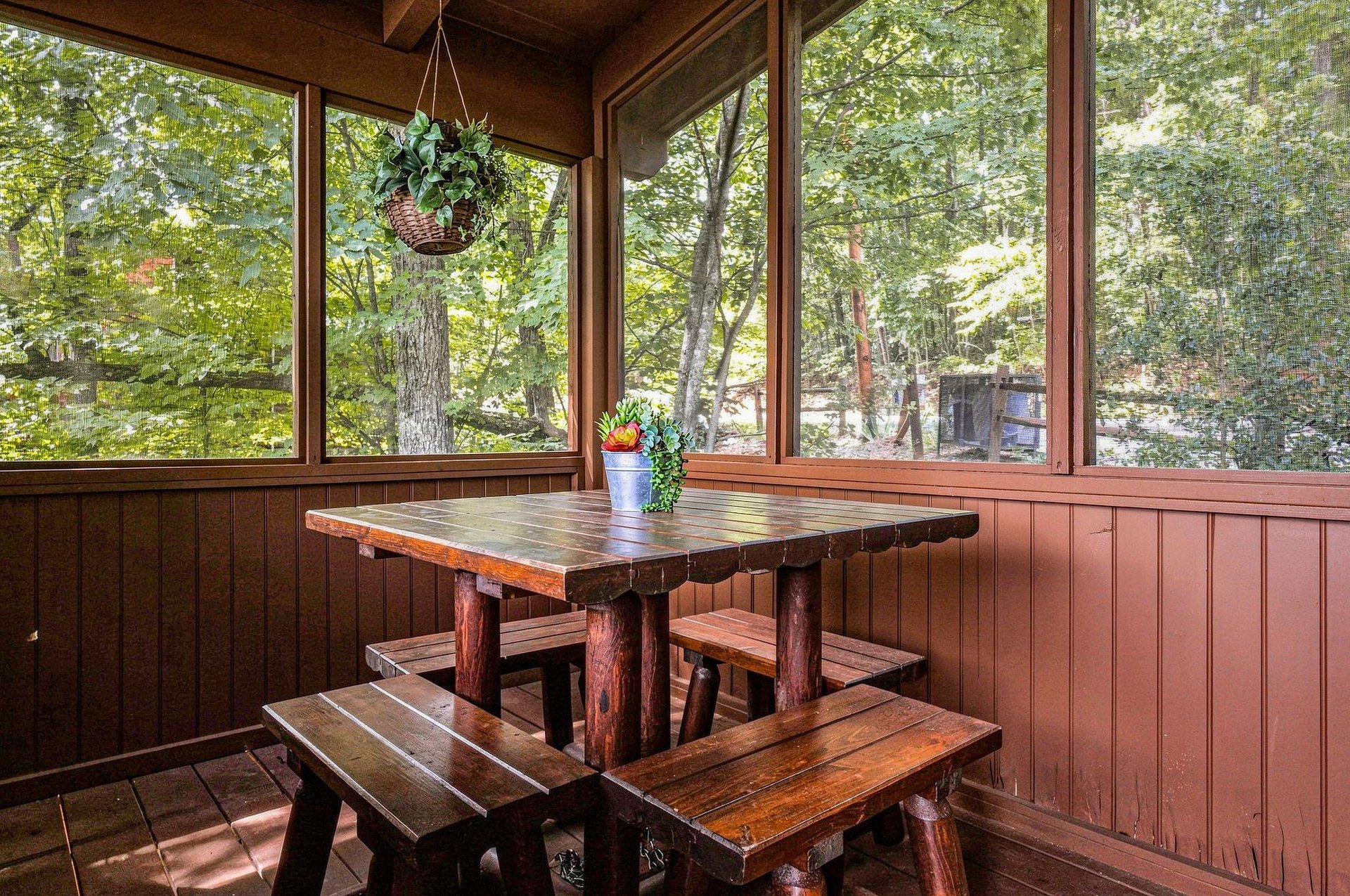 Your screened porch offers peaceful forest views and rustic charm, perfect for morning coffee or casual meals surrounded by nature.