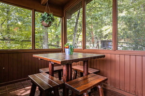 Your screened porch offers peaceful forest views and rustic charm, perfect for morning coffee or casual meals surrounded by nature.