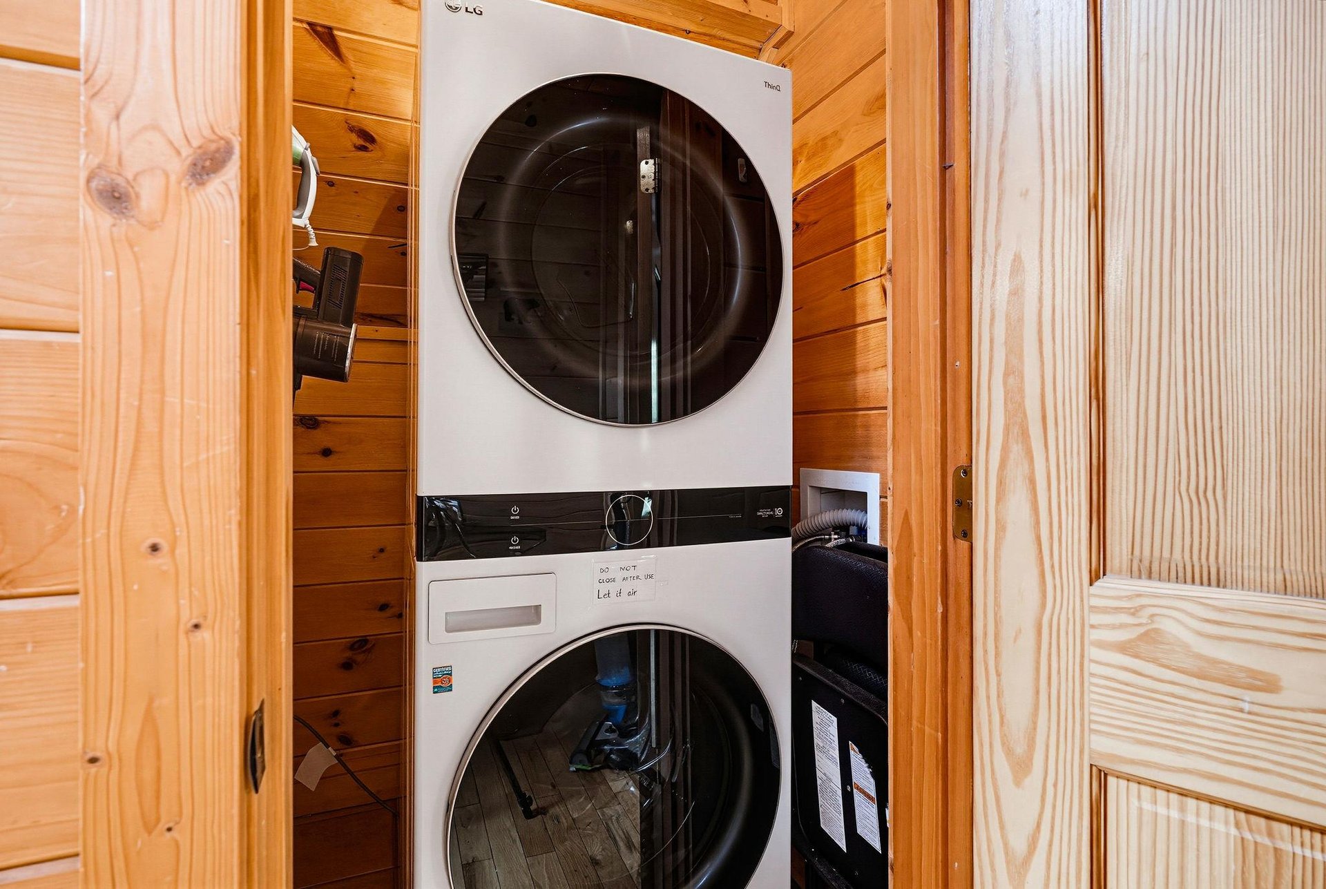 A stackable washer and dryer tucked into your private laundry closet ensures fresh clothes throughout your stay, with warm wood paneling adding cozy cabin charm.