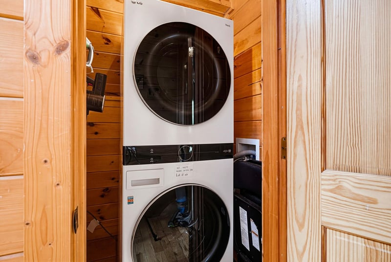 A stackable washer and dryer tucked into your private laundry closet ensures fresh clothes throughout your stay, with warm wood paneling adding cozy cabin charm.