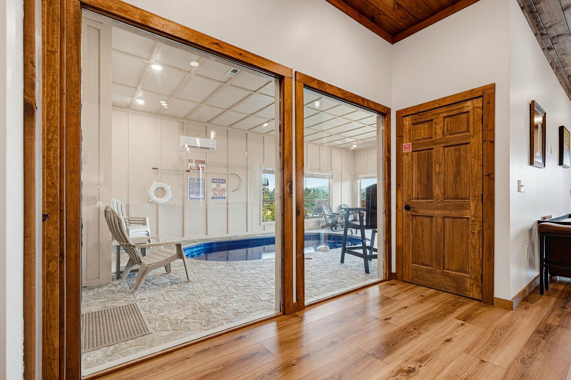 Step inside to discover your private indoor pool retreat, complete with lounge chairs and a sundrenched patio just beyond the glass doors. The warm wood tones and vaulted ceilings create a welcoming 
