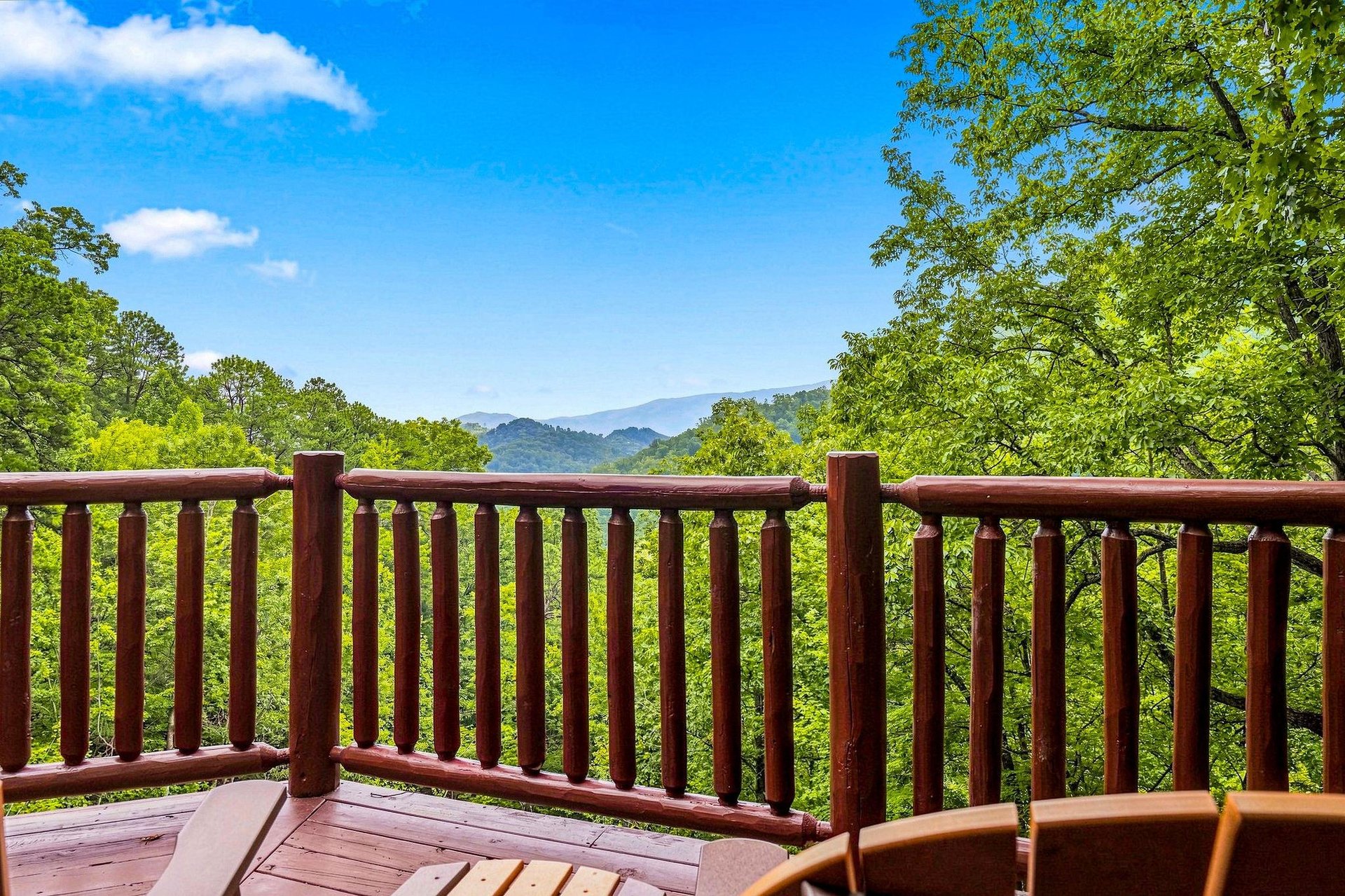 A peaceful mountain view framed by lush greenery stretches across the horizon, offering a serene backdrop for morning coffee or evening relaxation on this private deck.
