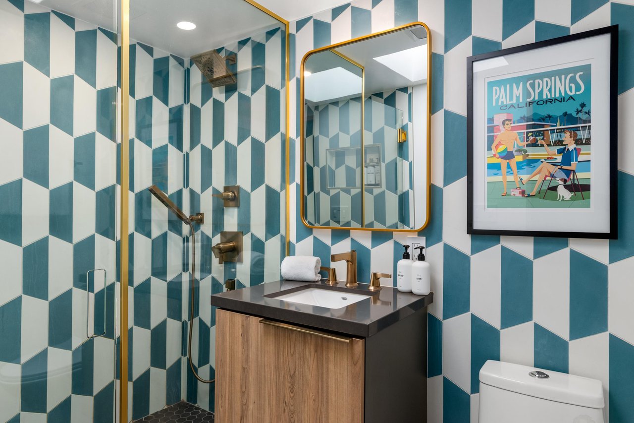 Step into your stylish bathroom featuring bold geometric wallpaper, brass fixtures, and curated artwork that transforms your daily routine into a design experience.
