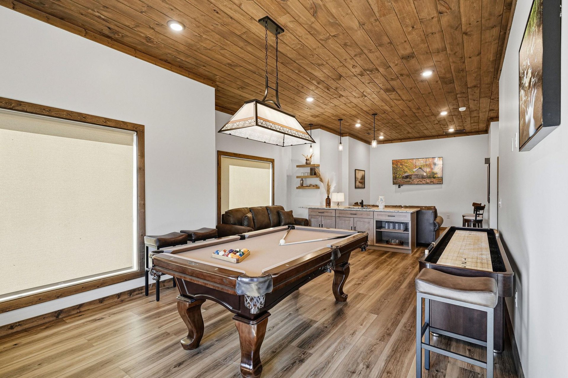 Your private game room features a beautiful pool table under rustic wood ceilings, perfect for friendly competition and memorable evenings.