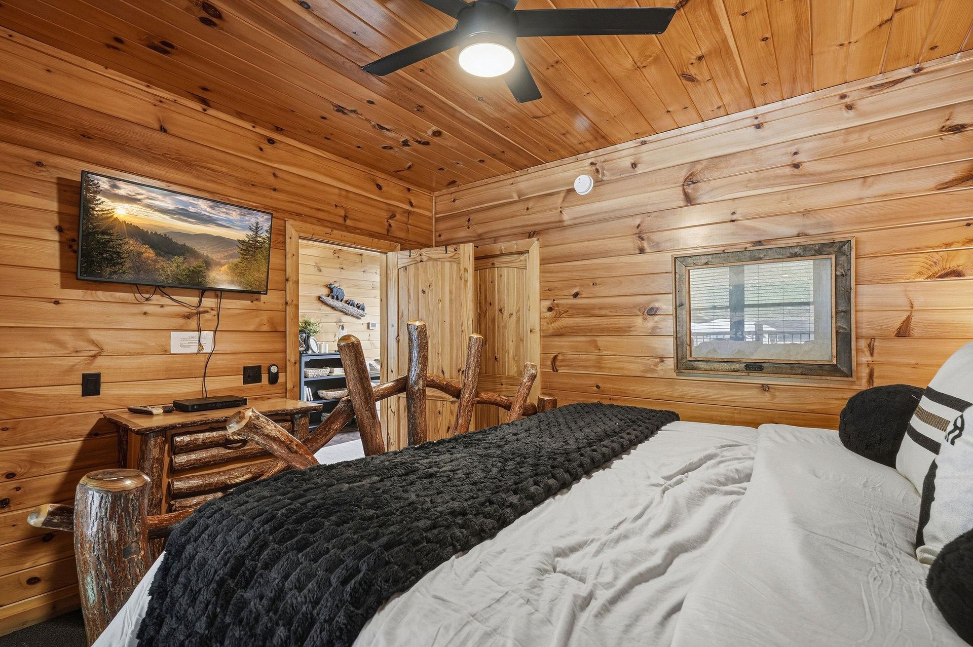 Curl up in your cozy cabin bedroom, where rustic pine walls and handcrafted log furniture create a warm mountain retreat, perfect for unwinding after a day of adventure.
