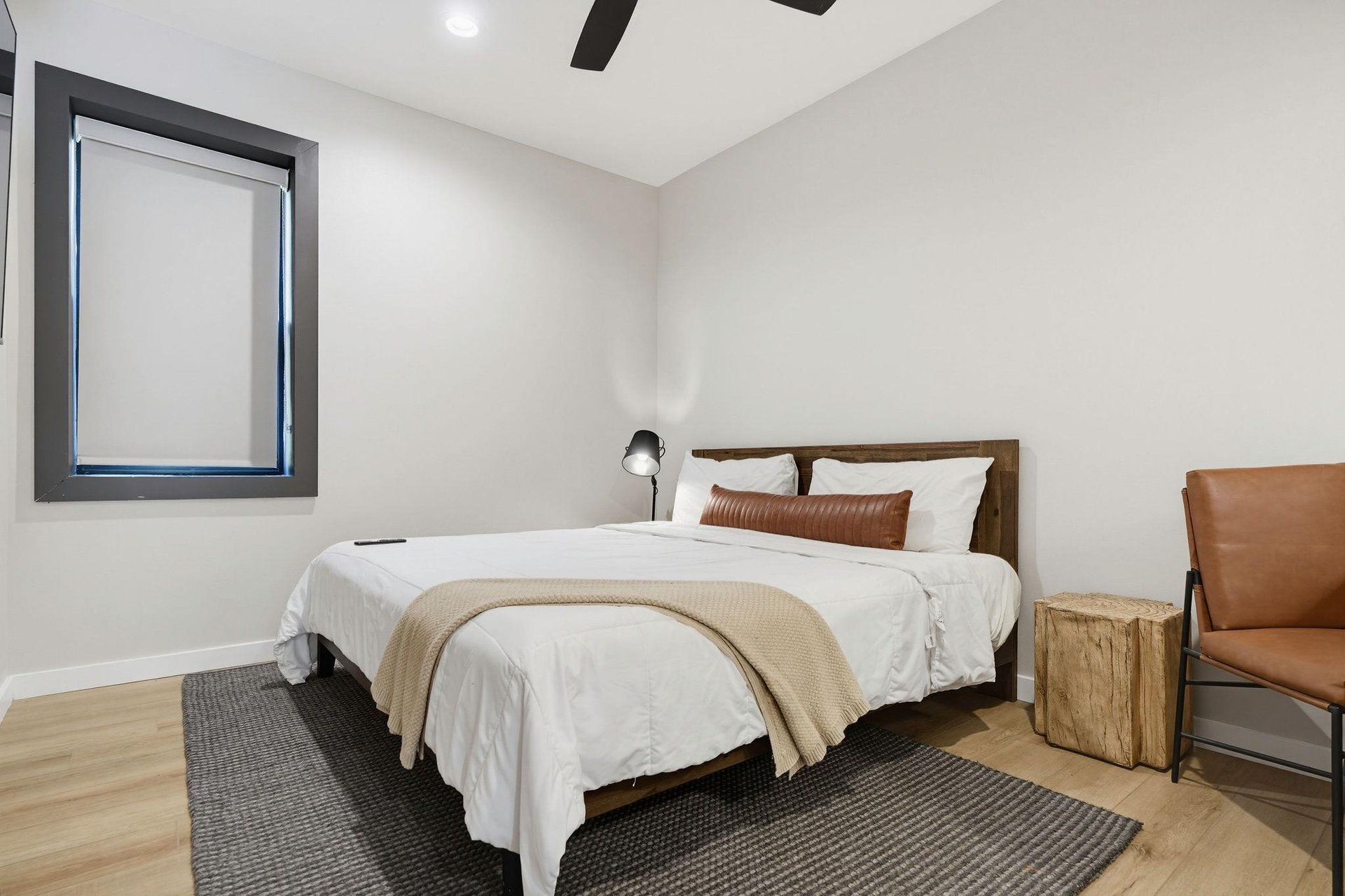 Sink into crisp, white linens and modern comfort in your thoughtfully designed bedroom, complete with rustic wood accents and a cozy reading chair.