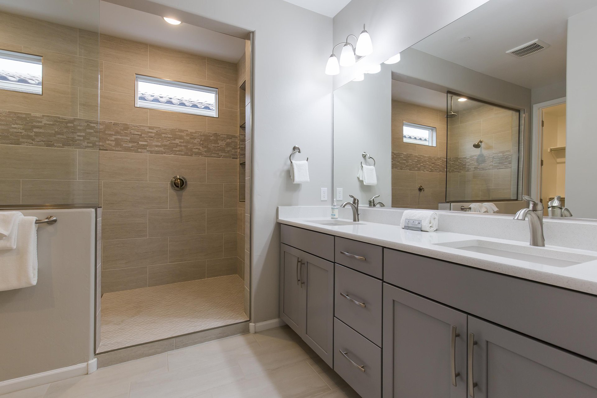 Ensuite bathroom with walkin shower, dual vanity sinks, and walkin closet.