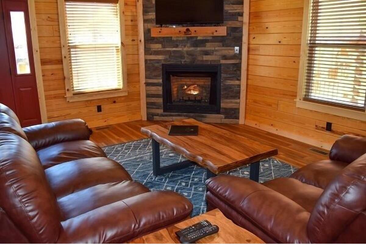 Cozy up in rich leather recliners by your stone fireplace, where warm flames create perfect ambiance for movie nights together.