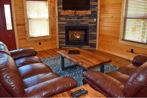 Cozy up in rich leather recliners by your stone fireplace, where warm flames create perfect ambiance for movie nights together.