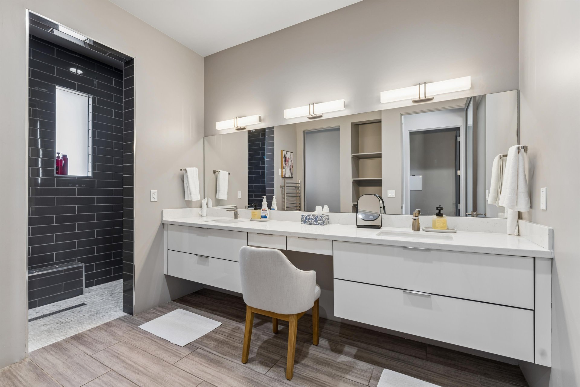 Ensuite bathroom with dual vanity sinks, vanity, and a walkin shower