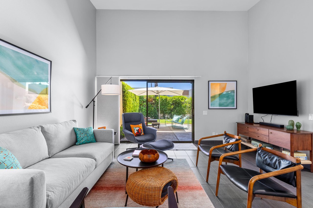Living room has direct patio access, smart TV, ample seating, and openconcept living space.