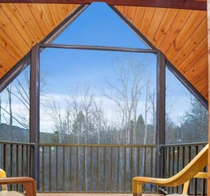 Soaring cathedralstyle windows frame peaceful forest views from your private retreat, where warm wood tones create a cozy sanctuary.