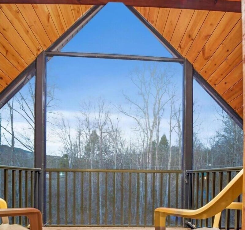 Soaring cathedralstyle windows frame peaceful forest views from your private retreat, where warm wood tones create a cozy sanctuary.