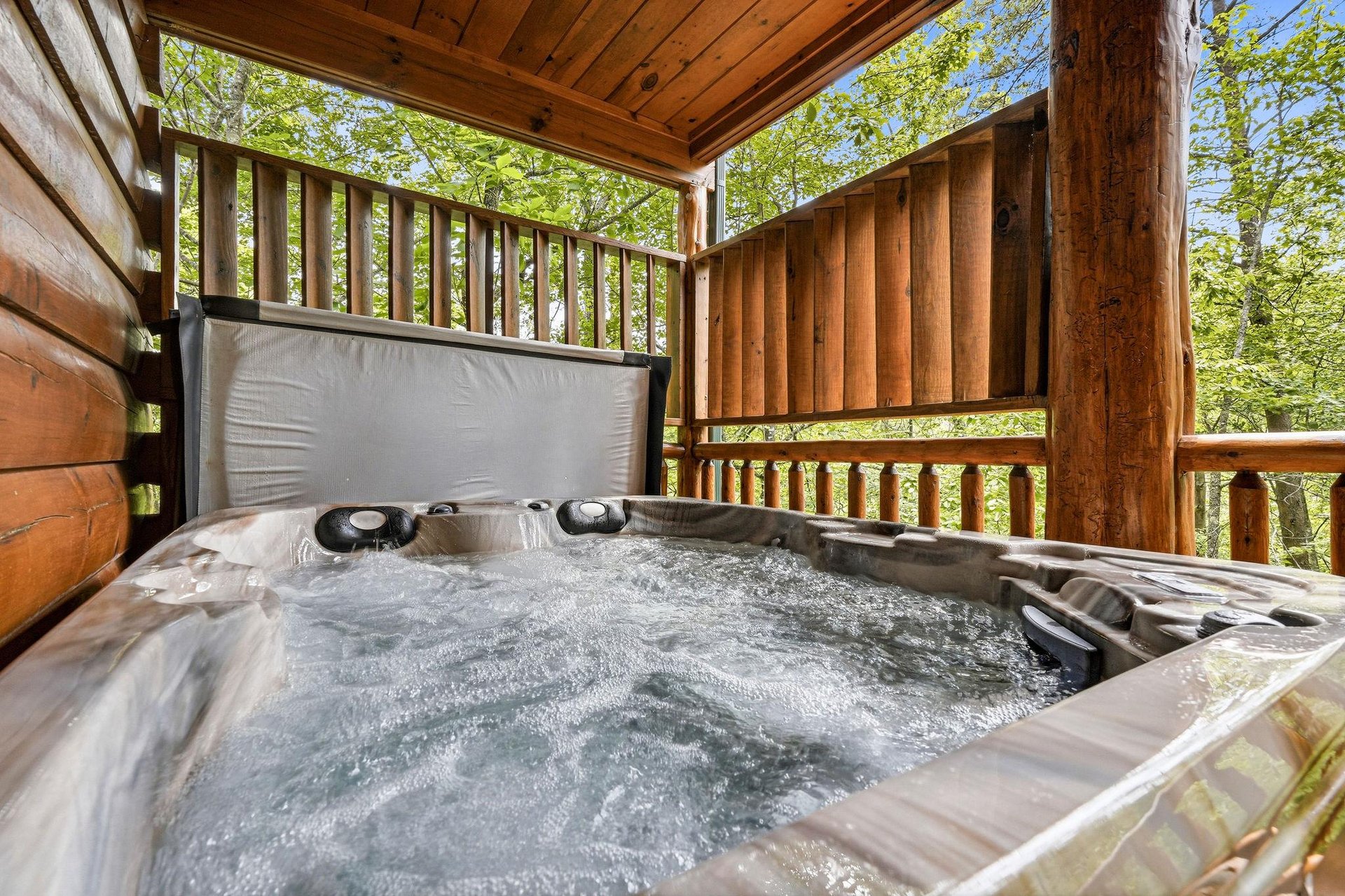 Sink into the bubbling hot tub on your private covered deck, surrounded by lush forest views and fresh mountain air—your ultimate escape awaits.