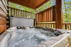 Sink into the bubbling hot tub on your private covered deck, surrounded by lush forest views and fresh mountain air—your ultimate escape awaits.