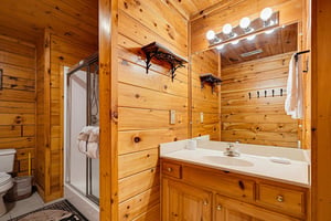 Your private bathroom features warm wood paneling and everything you need to refresh after a day of exploring. The bright vanity lighting and cozy cabin touches make it easy to settle in.