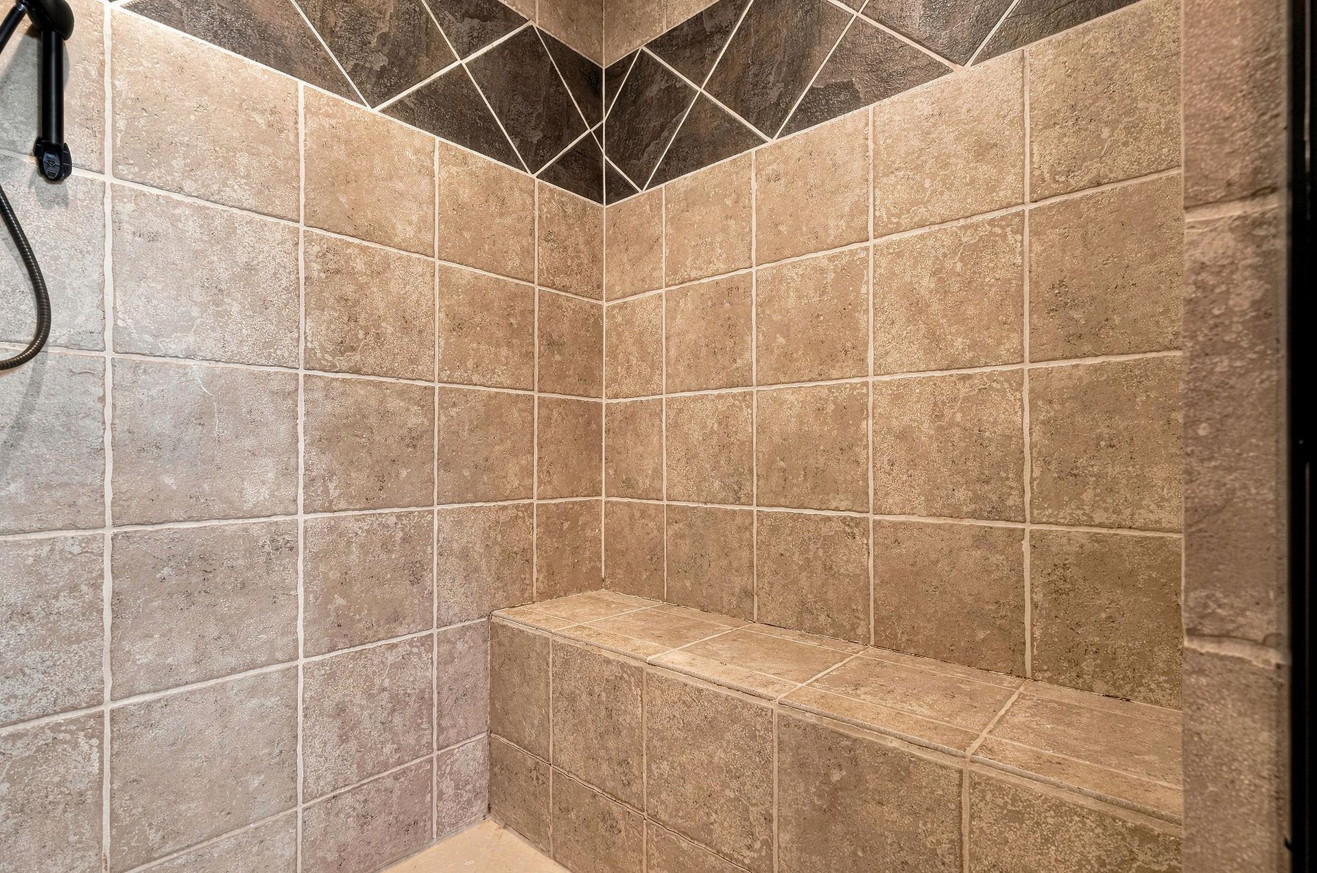 Beautifully tiled shower with a builtin bench where you can sit and let the warm water wash over you after a long day of exploring.