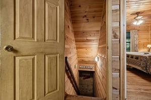 Charming wooden staircase leads down to a cozy retreat, with warm knotty pine walls inviting you to explore the unique spaces below.