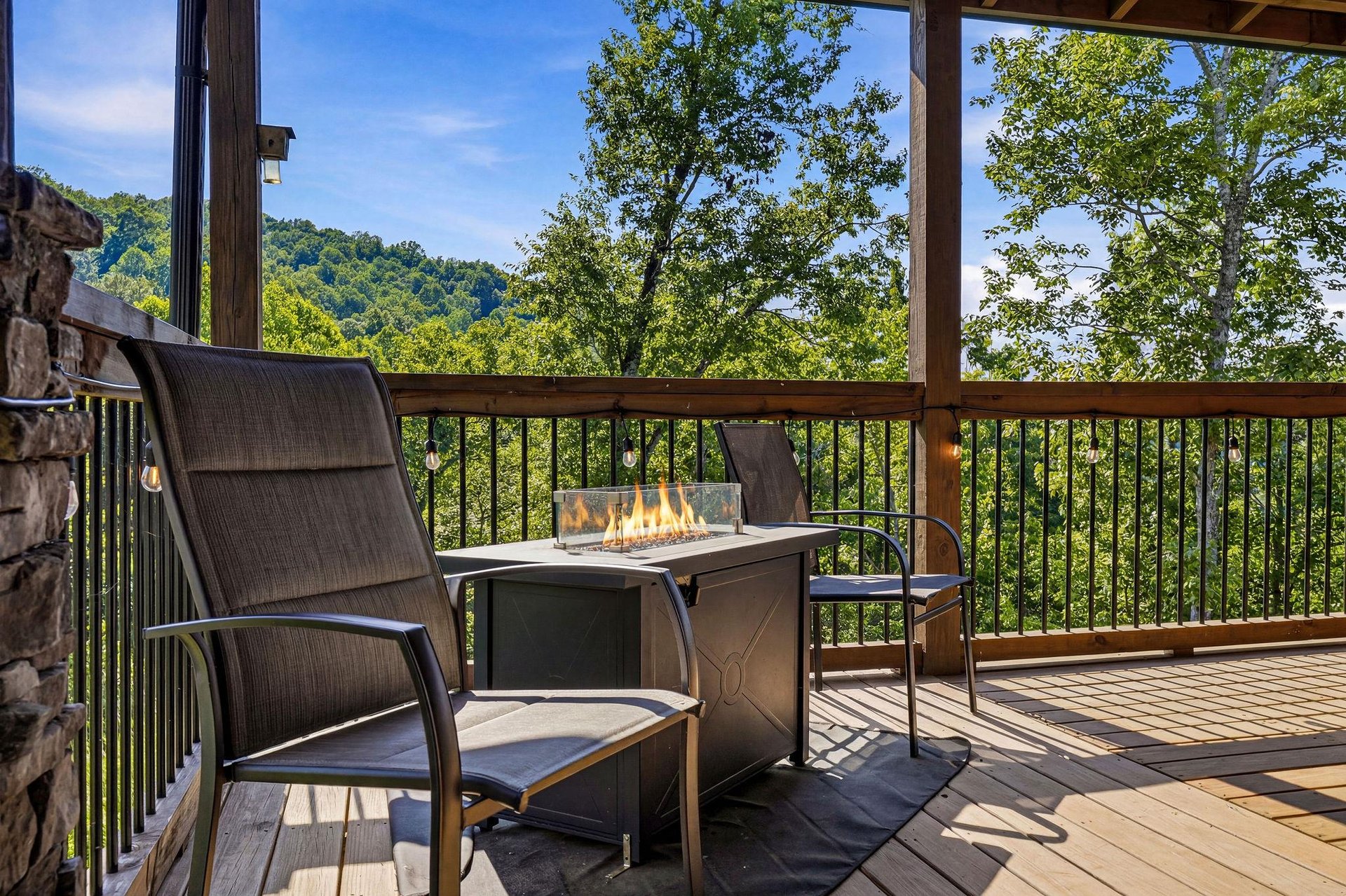 Step outside to your private covered deck and unwind with stunning mountain and forest views stretching beyond the railing. A cozy fire table waits, perfect for morning coffee or evening gatherings un