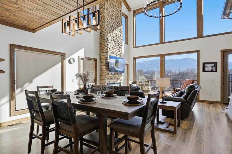 Your openconcept living space combines rustic charm with mountain views. Gather around the dining table or unwind by the stone fireplace.