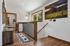 Bright hallway with warm wood tones and natural light leads to your private retreat downstairs.