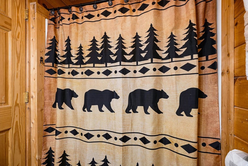A rustic shower curtain with bear and pine tree silhouettes adds charming cabin character to your private bathroom.