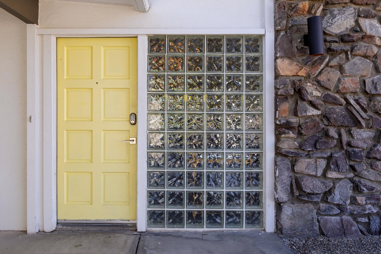Welcome to your cheerful getaway The bright yellow door creates a warm first impression as you arrive at your vacation home.