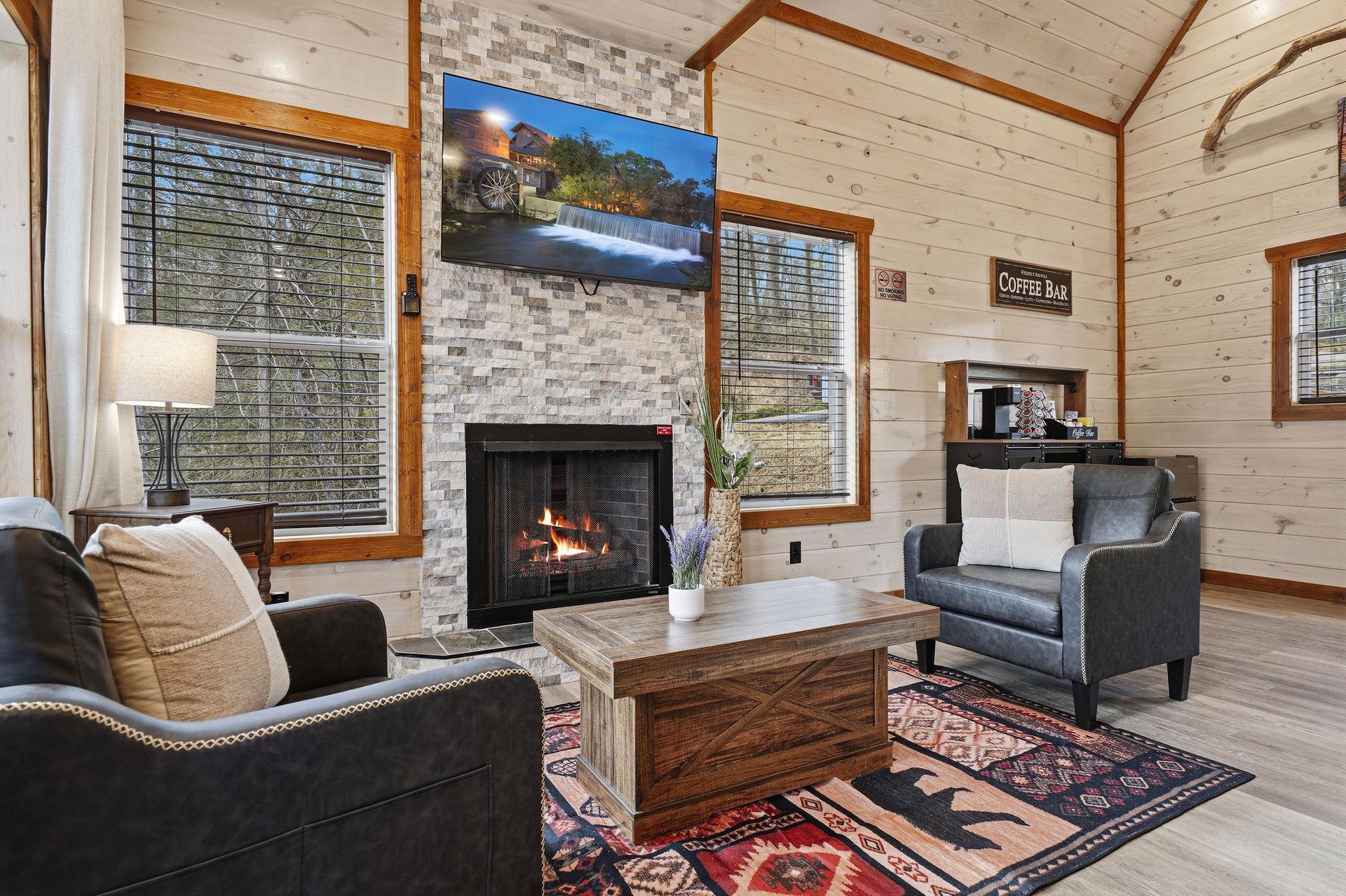 Cozy up by your crackling fireplace in this rustic living room with exposed beams and a coffee bar nearby.