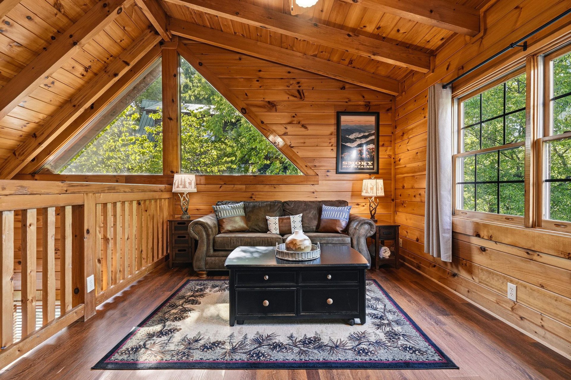 Cozy up in your rustic loft retreat with vaulted wood ceilings and peaceful forest views through oversized windows.