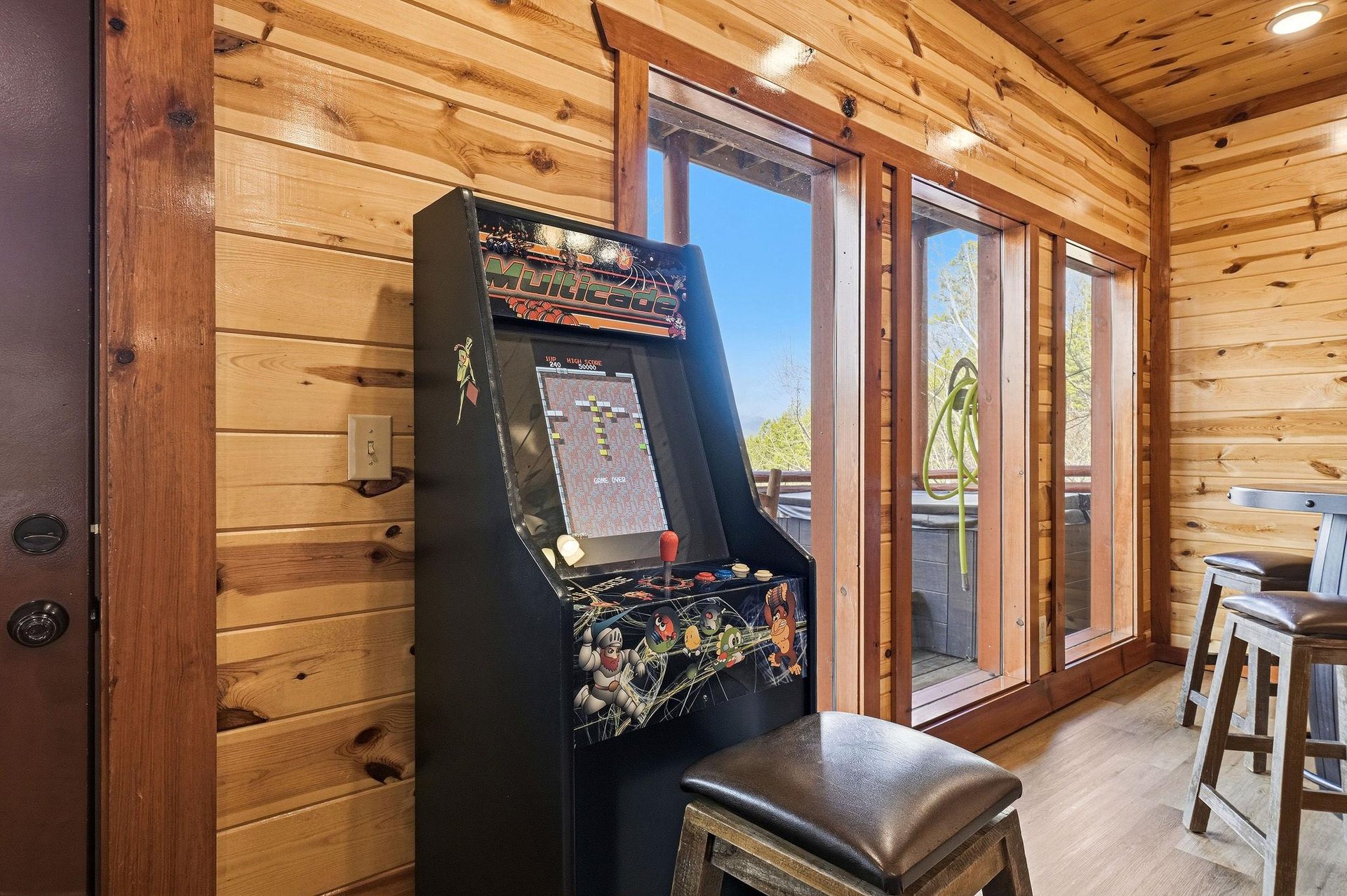 Challenge friends to classic arcade games in your cozy cabin retreat, where warm wood walls and mountain views create the perfect gaming atmosphere.