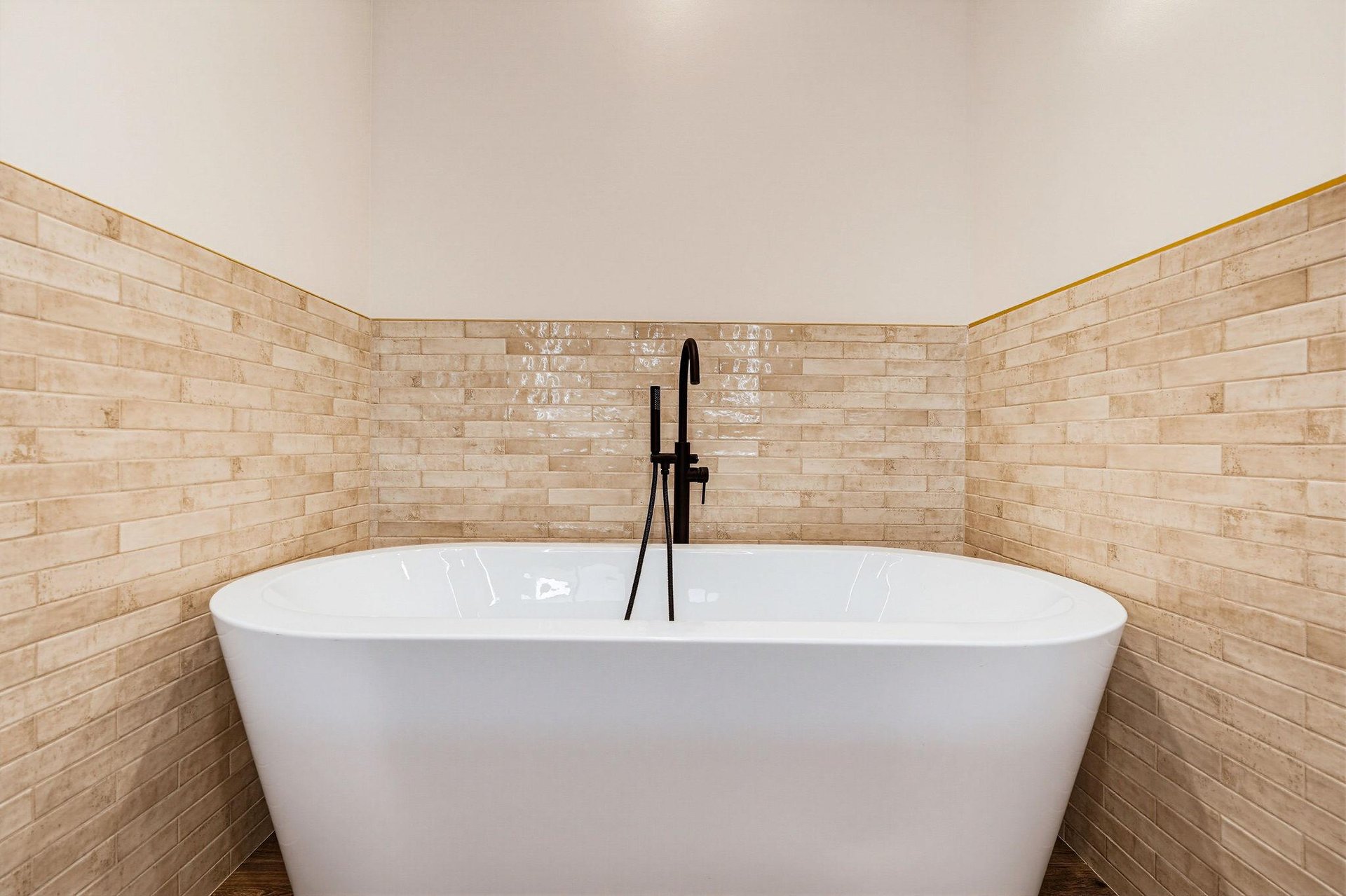 Step into a spalike sanctuary with a sleek freestanding tub and warm tiled accent walls, perfect for unwinding after your adventures.