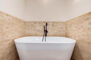Step into a spalike sanctuary with a sleek freestanding tub and warm tiled accent walls, perfect for unwinding after your adventures.