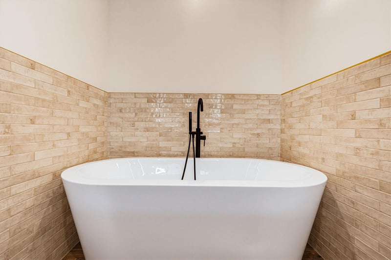 Step into a spalike sanctuary with a sleek freestanding tub and warm tiled accent walls, perfect for unwinding after your adventures.