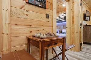 Cozy woodpaneled nook with a chess table invites you to unwind and enjoy a friendly game while soaking in the cabins warm, rustic charm.