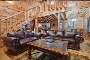 Sink into plush leather sofas surrounded by warm wood walls and beams that create your perfect mountain retreat atmosphere.