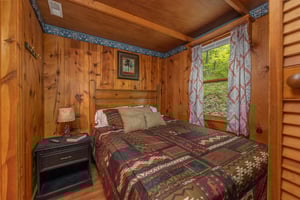 Bedroom with a bed, night stand, and lamp at Heavenly Hideaway, a 2bedroom cabin rental located in Gatlinburg