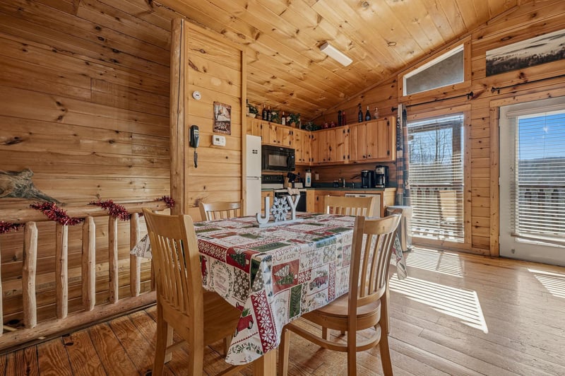 Warm wooden dining space with rustic charm where youll gather for memorable meals surrounded by natural light and mountain cabin comfort.