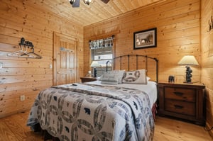 Cozy up in your rustic cabin bedroom with warm pine walls, charming bearthemed decor, and peaceful woodland touches that invite you to unwind after a day of adventure.
