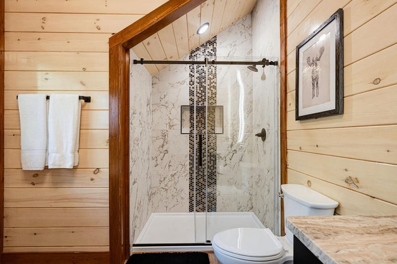 Refresh after your adventures in a beautifully appointed bathroom with a walkin shower and warm wood accents.