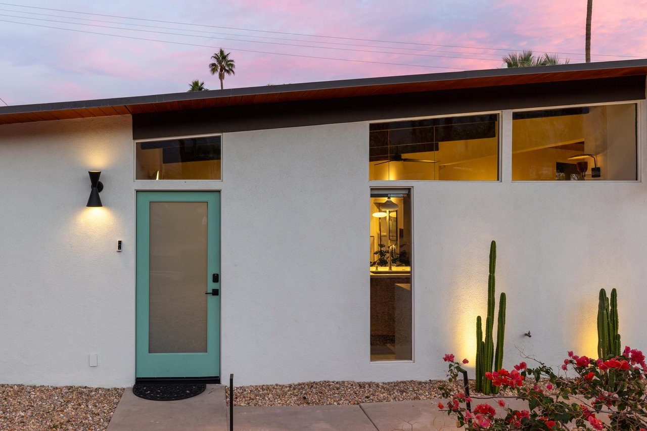 Modern desert retreat showcasing clean architectural lines and desert landscaping beneath a vibrant evening sky.