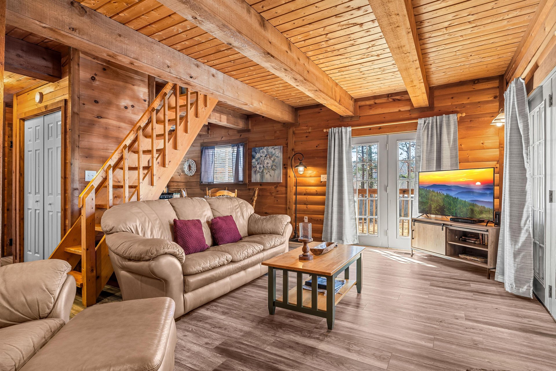 Sofa and stairs to the bedroom at Living on Love, a 2 bedroom cabin rental located in Pigeon Forge