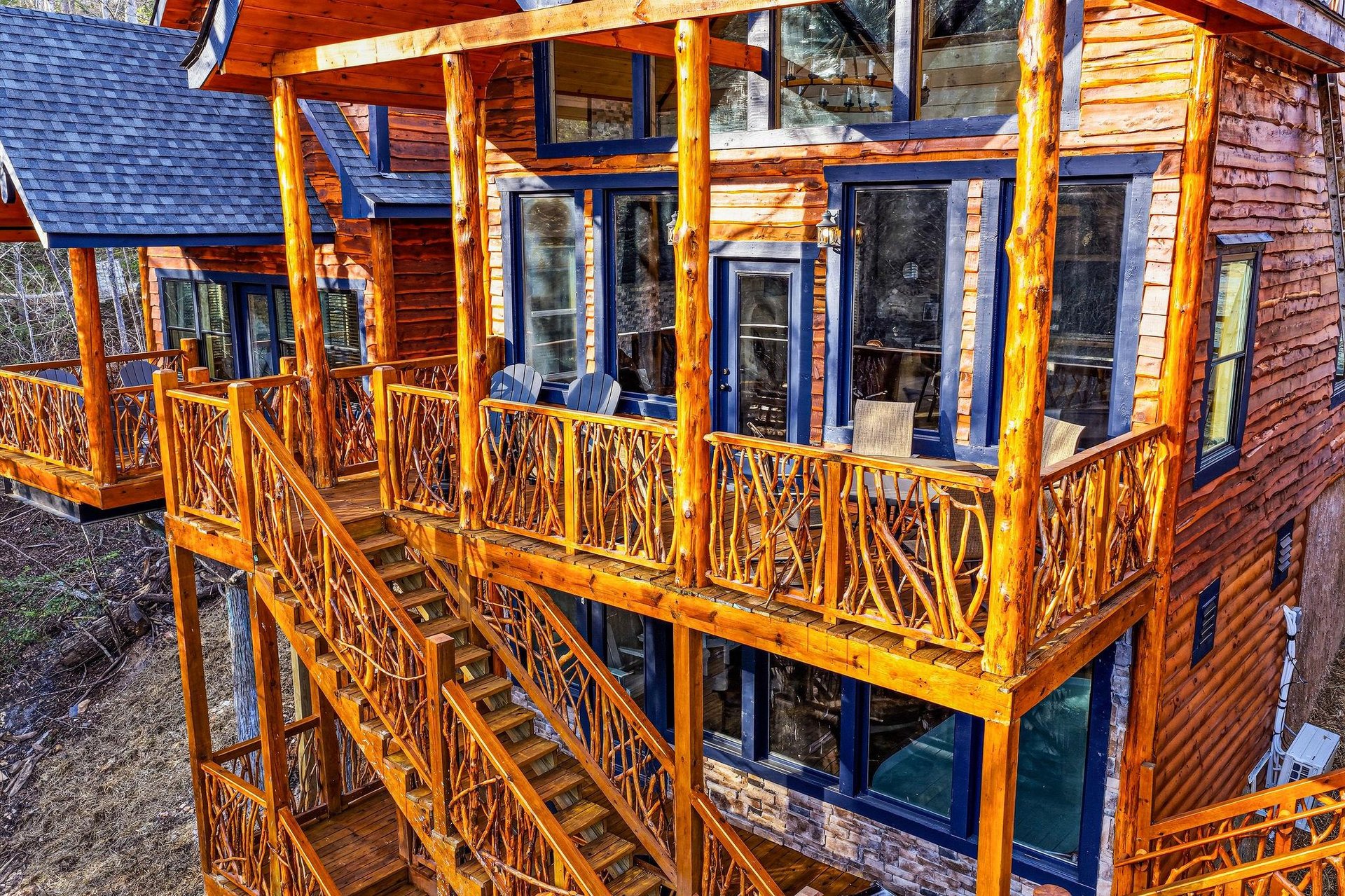 Rustic log cabin featuring expansive wooden balconies with handcrafted railings and mountain lodge charm.