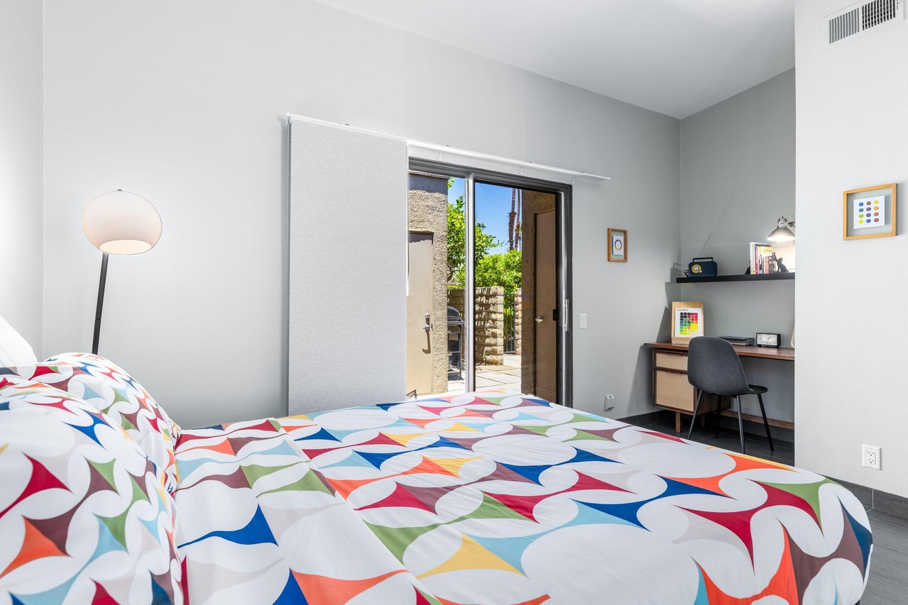 Queen size bed, desk space, and front patio access.