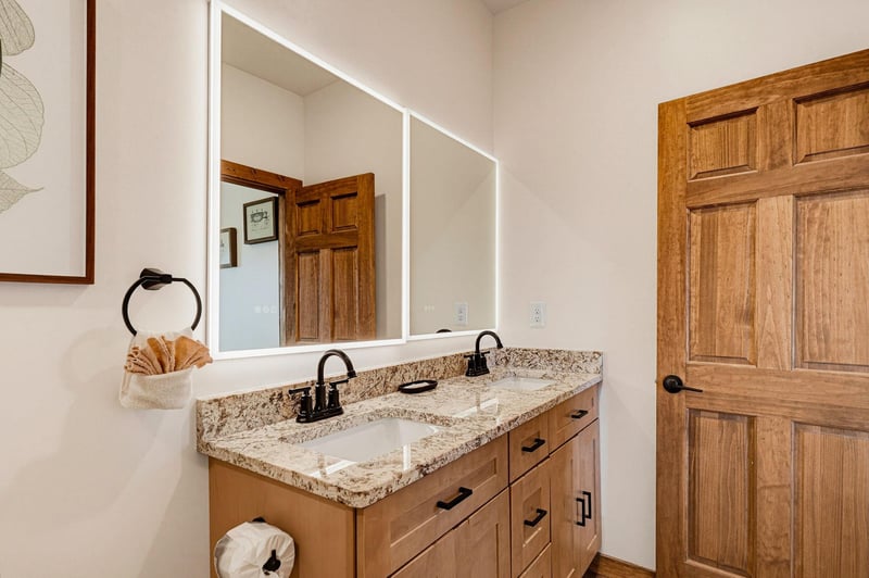 Your dualsink vanity makes morning routines a breeze, with warm wood tones, granite counters, and soft lighting that sets a calm, welcoming tone.