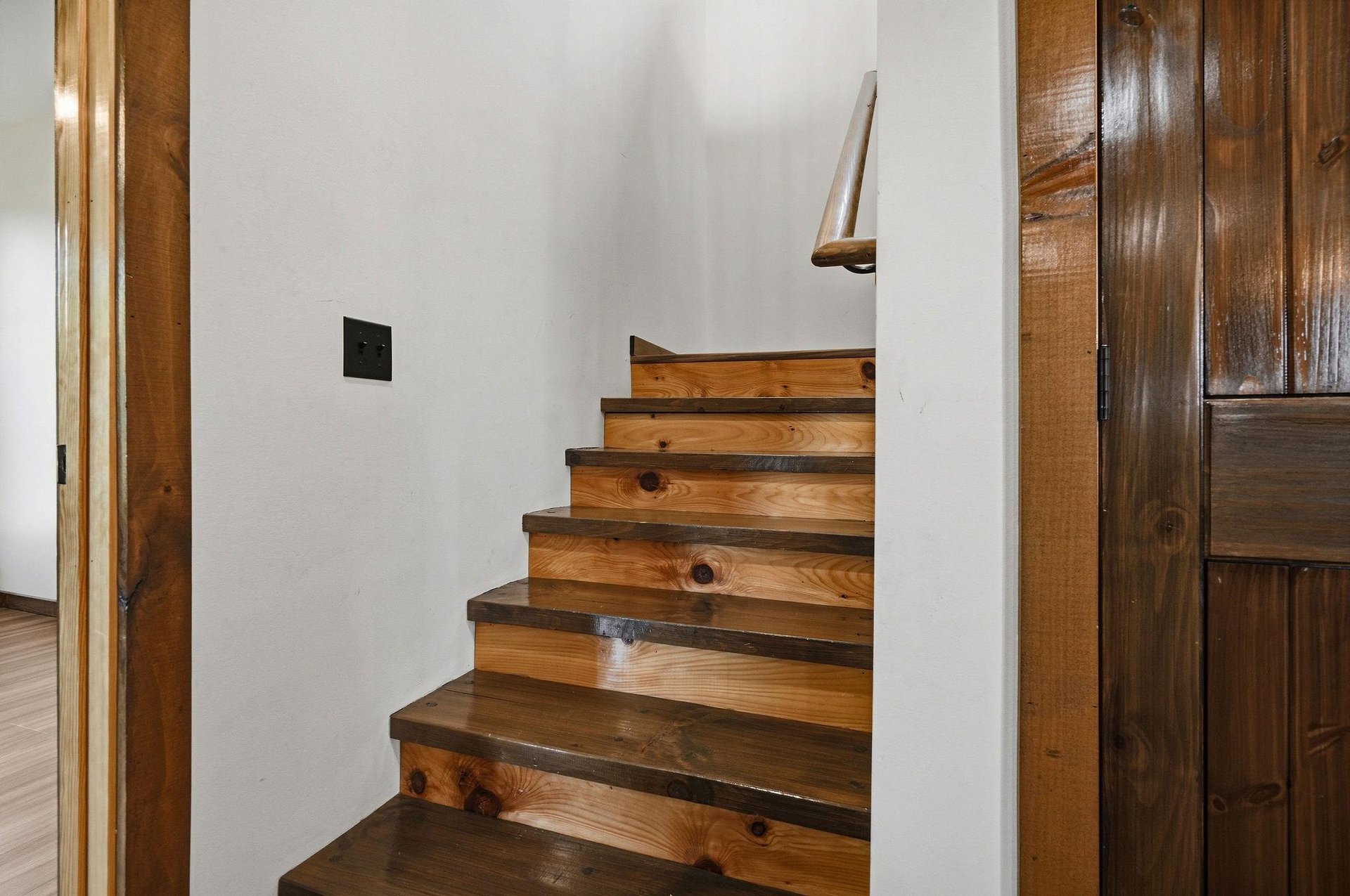 Rustic wooden stairs lead you upstairs, adding warmth and character with their natural grain and sturdy craftsmanship.