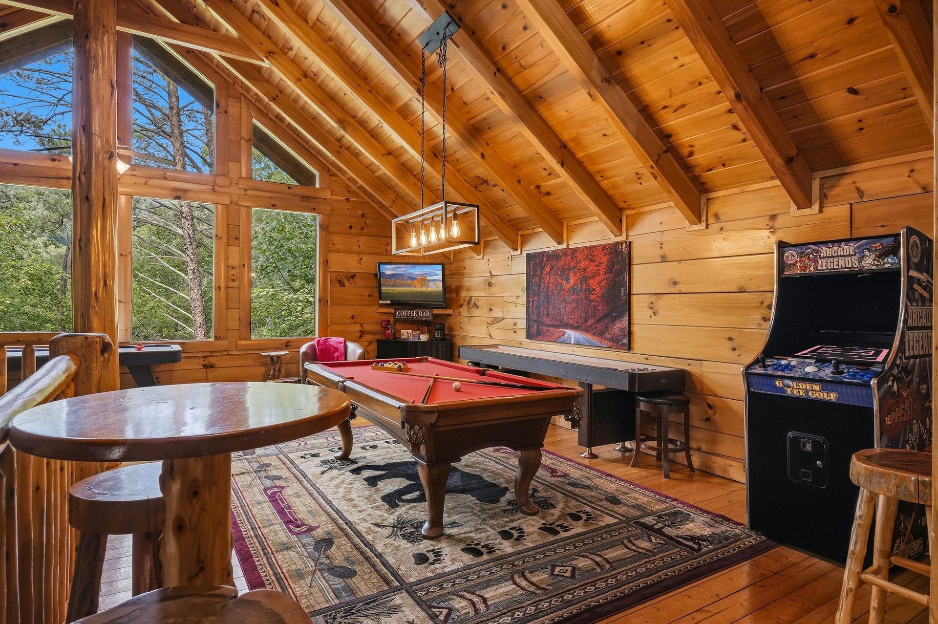 Your own game room awaits with a pool table and classic arcade fun, all under stunning vaulted wood ceilings with natural light streaming in.