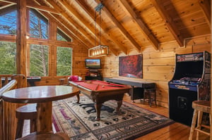 Your own game room awaits with a pool table and classic arcade fun, all under stunning vaulted wood ceilings with natural light streaming in.