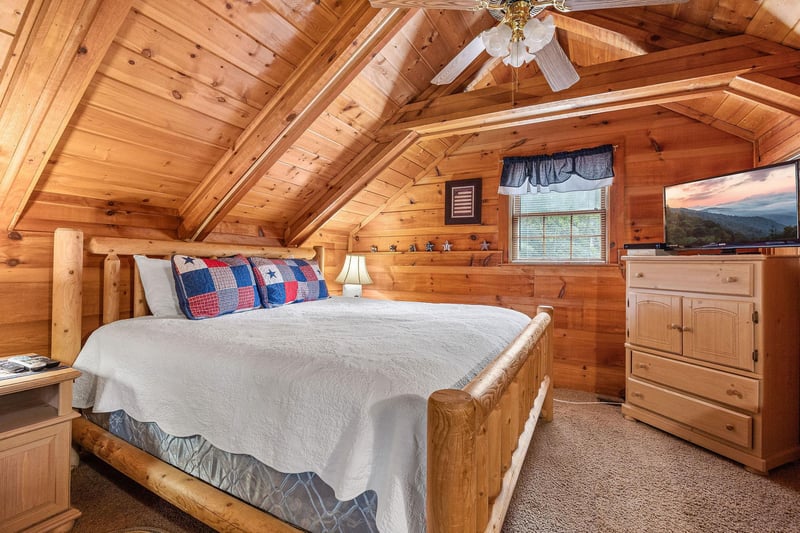 Bedroom with a log bed, night table, and lamp at Beary Good Time, a 1bedroom cabin rental located in Pigeon Forge